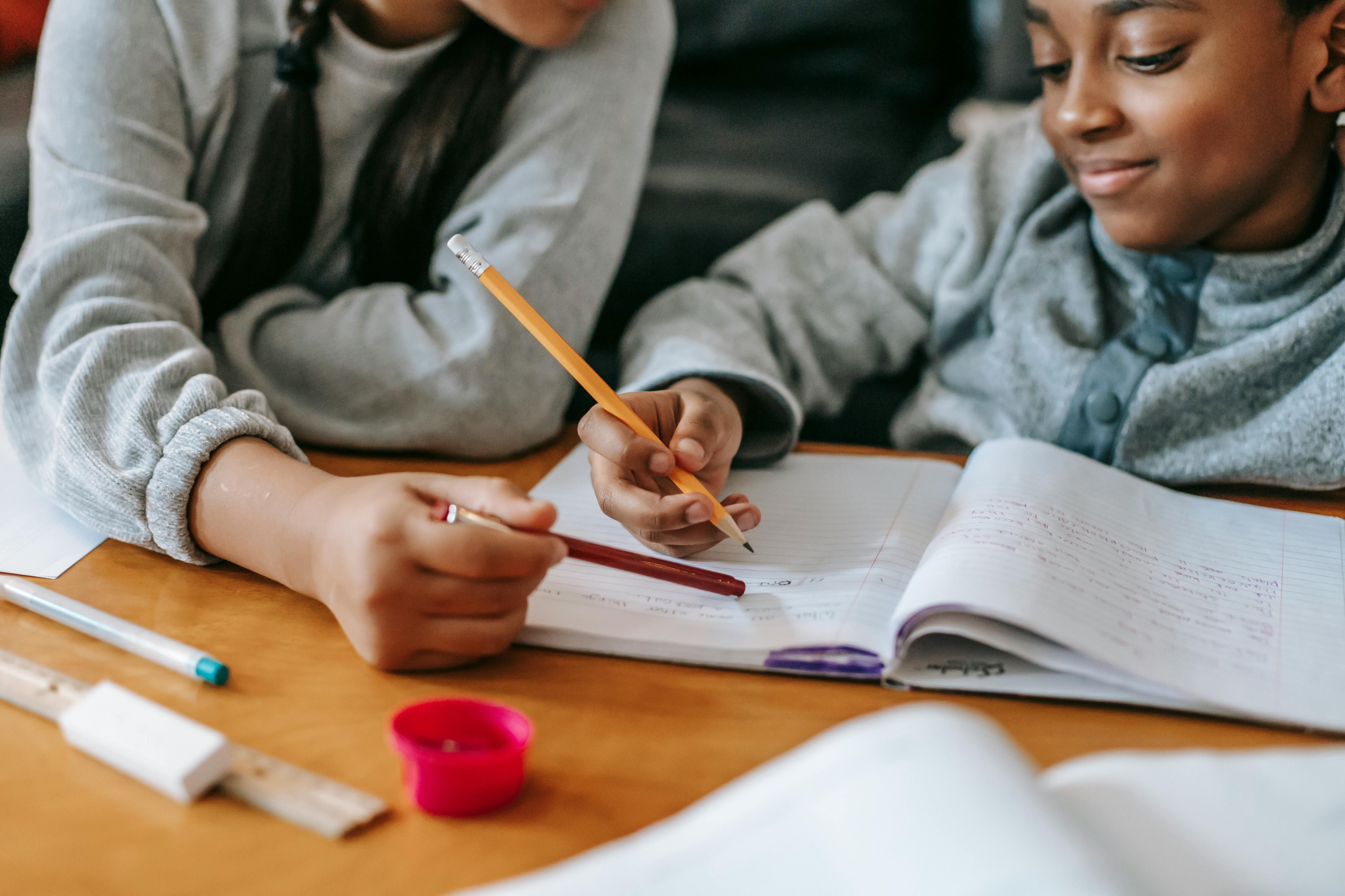 A child with a pencil in hand, looking at a notebook.